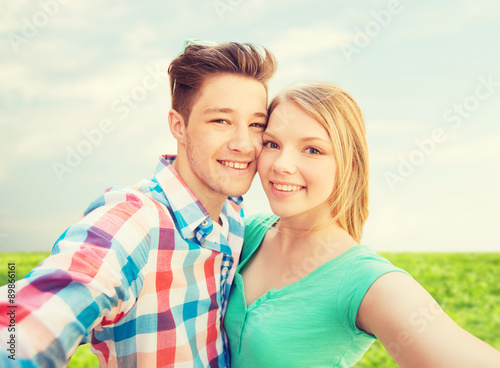 smiling couple with smartphone in suburbs