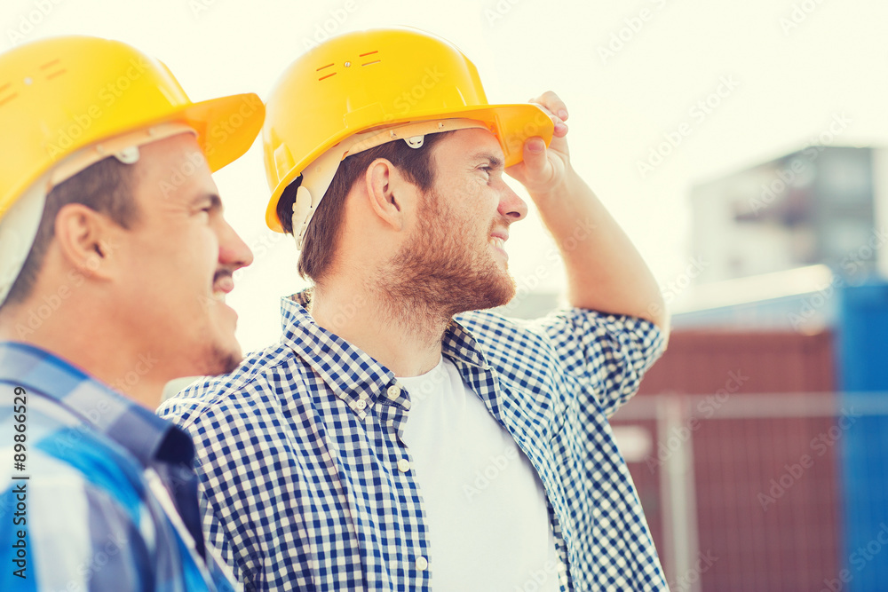 group of smiling builders in hardhats outdoors