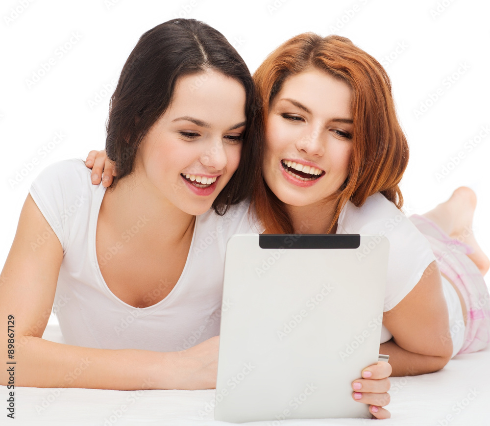 two smiling teenage girsl with tablet pc computer two smiling teenage girsl with tablet pc computer