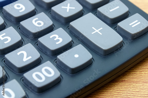 calculator plus button on a wooden.