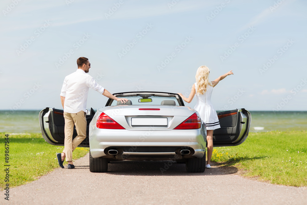 happy man and woman near cabriolet car at sea happy man and woman near cabriolet car at sea