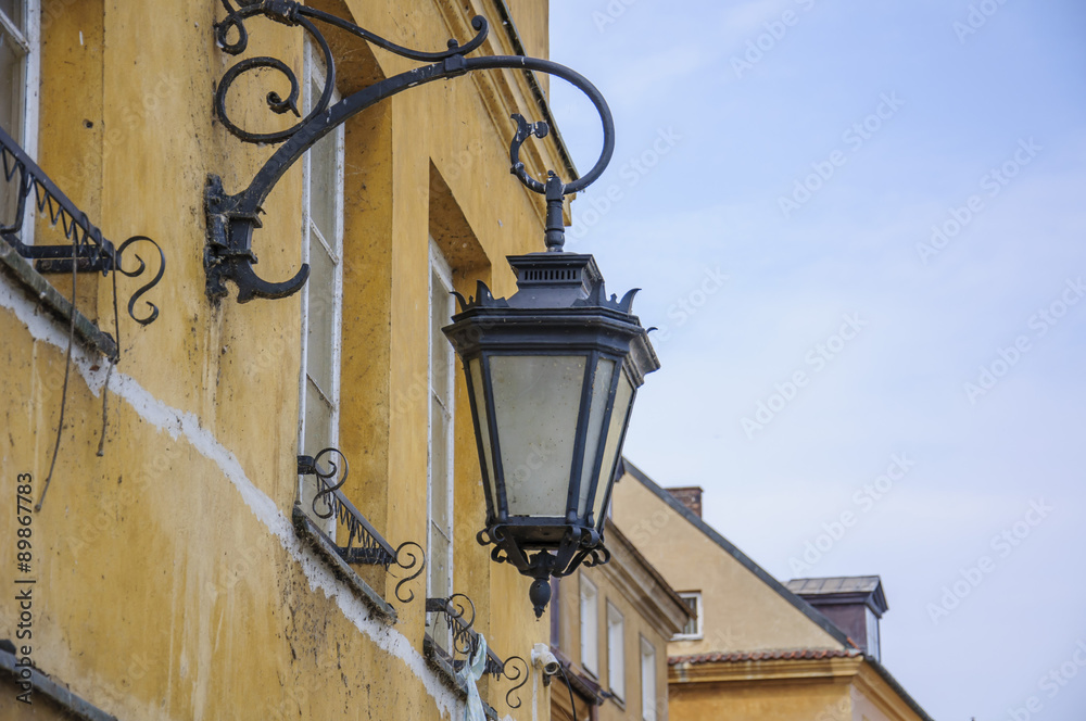 Старинный металлический фонарь висящий на доме