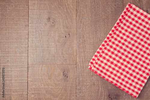 Abstract wooden texture background with red checked tablecloth. View from above