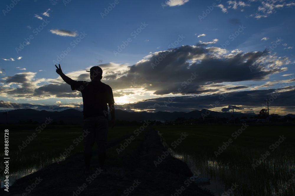 Fototapeta premium man standing alone at the mountain during beautiful sunset