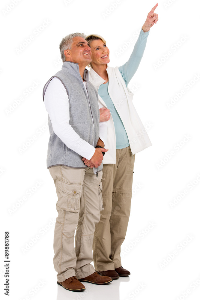 senior couple pointing at empty copy space senior couple pointing at empty copy space