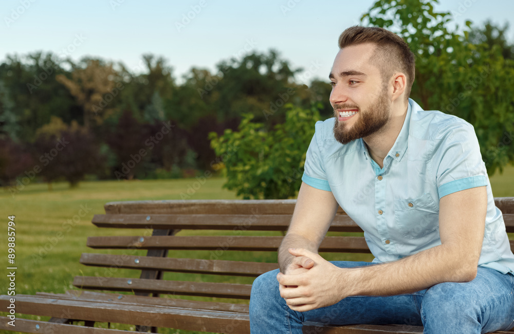 Young man relaxing on park bench Young man relaxing on park bench
