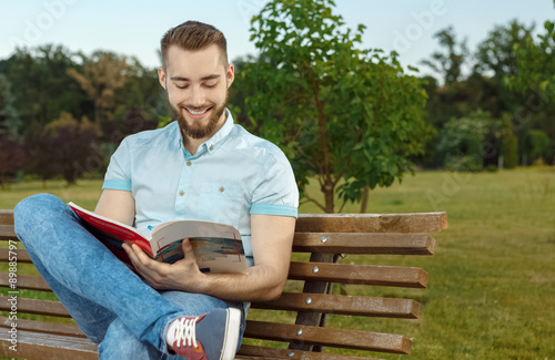 Young man reading book in the park