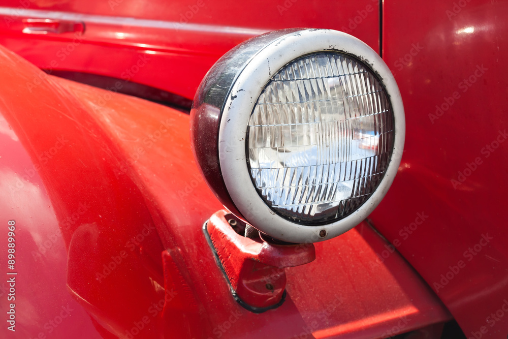 Retro automotive lamp. Red car body background