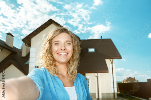 Happy girl taking selfie of her new house
