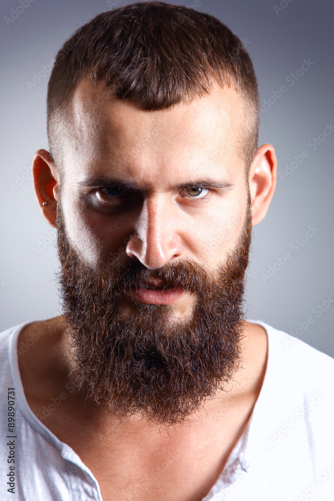 Portrait of handsome bearded man standing, isolated on grey Portrait of handsome bearded man standing, isolated on grey