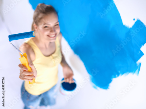 Beautiful young woman doing wall painting