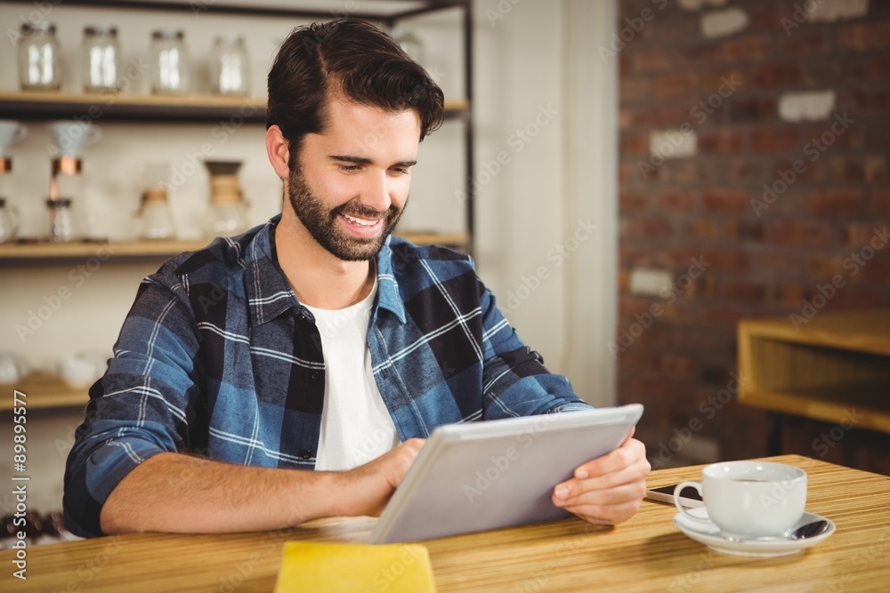  Young man having cup of coffee using tablet