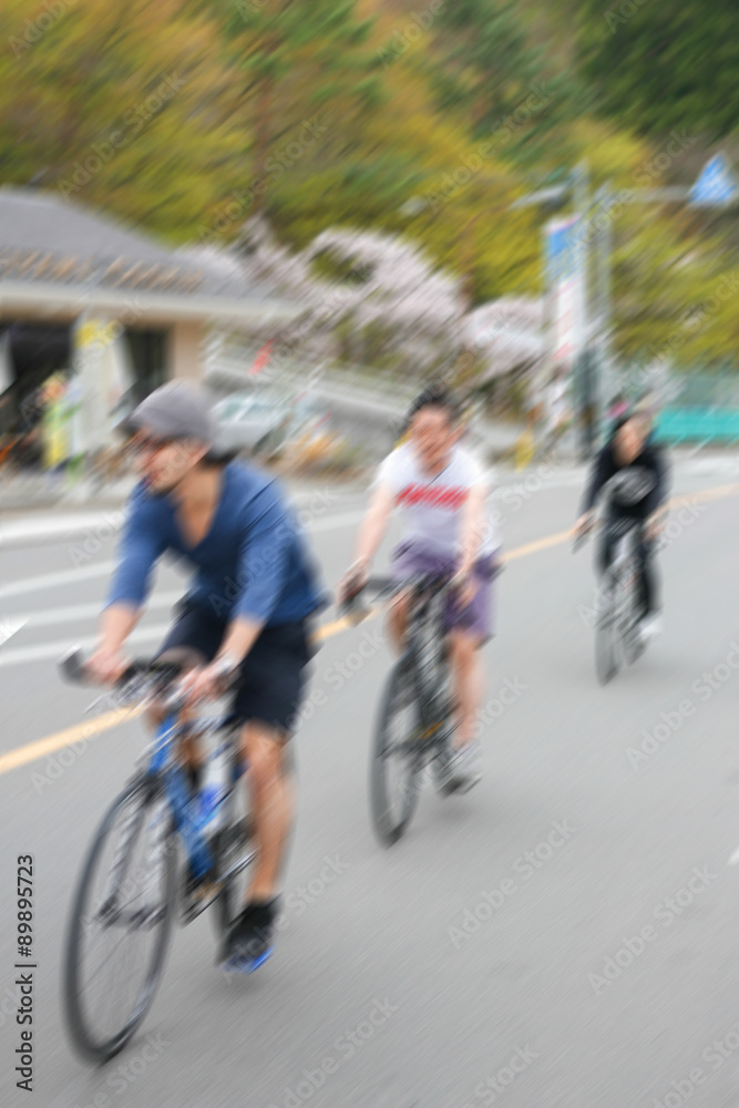 motion blur of three men cycling on the street