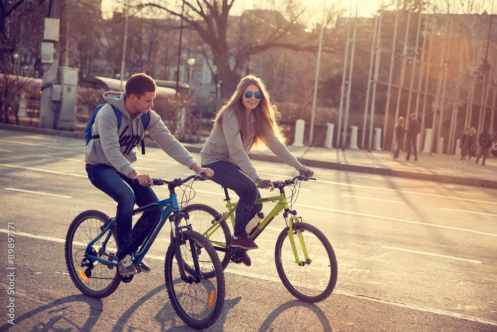 Fototapeta premium young couple on bicycles in the city at sunset