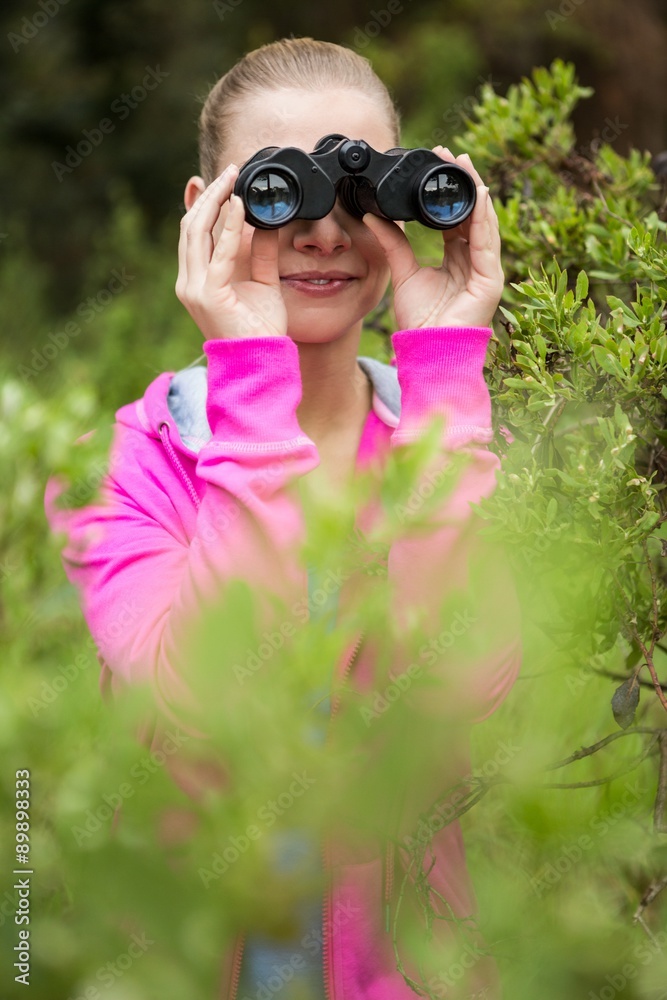 Female hiker looking through the binoculars Female hiker looking through the binoculars
