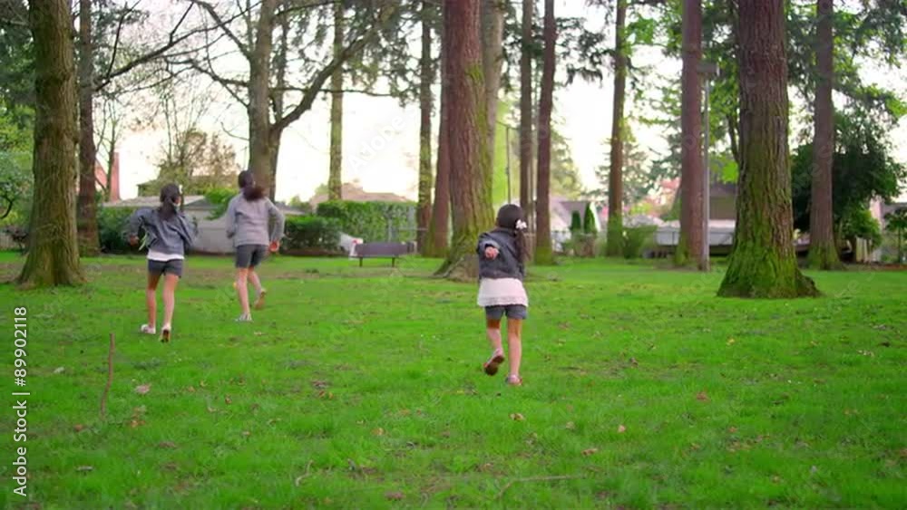Young girls chasing down a ball in a park
Young girls chasing down a ball in a park