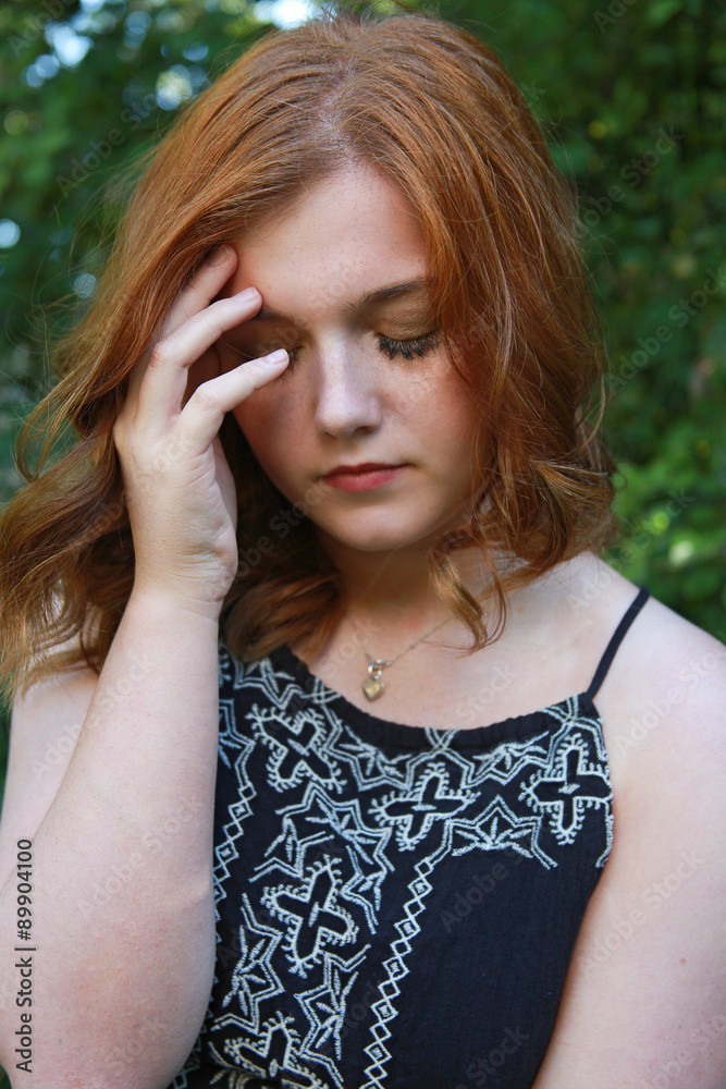 Beautiful young woman holding her head in her hands Beautiful young woman holding her head in her hands