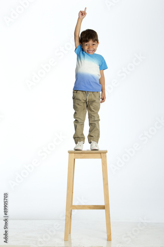 little boy standing on a stool