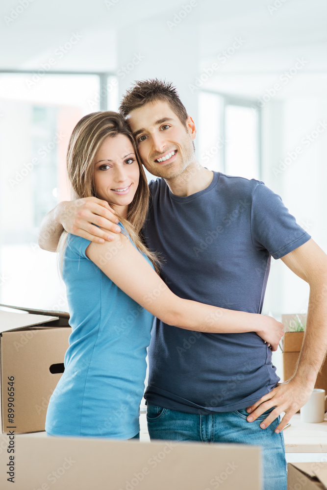 Fototapeta premium Young couple hugging in their new house
