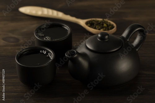 Black teapot, two cups on old wooden background . Menu, recipe