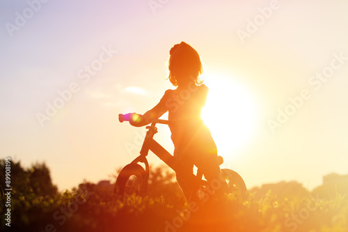 little girl riding bike at sunset