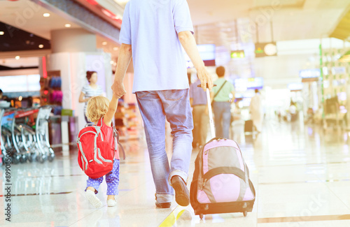 father and little daughter walking in the airport