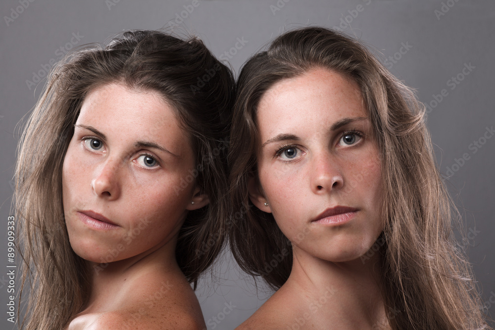Two Serious Twin Sisters Looking at Camera Two Serious Twin Sisters Looking at Camera