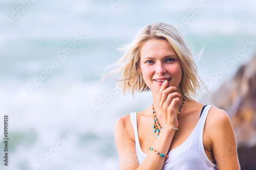 Beautiful young blonde woman posing outdoor at the rocky sea shore