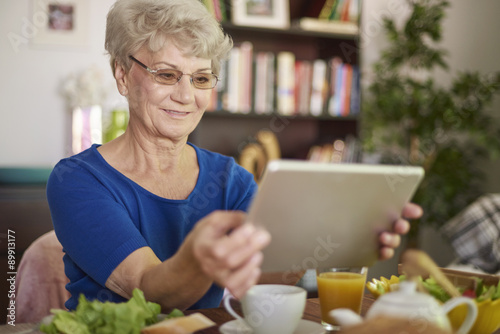 Cheerful grandmother using her digital tablet