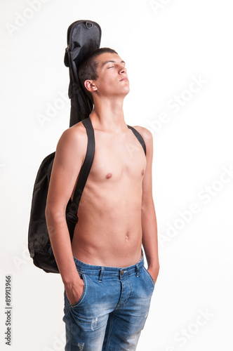 young guitarist wearing no top with his acoustic guitar on back