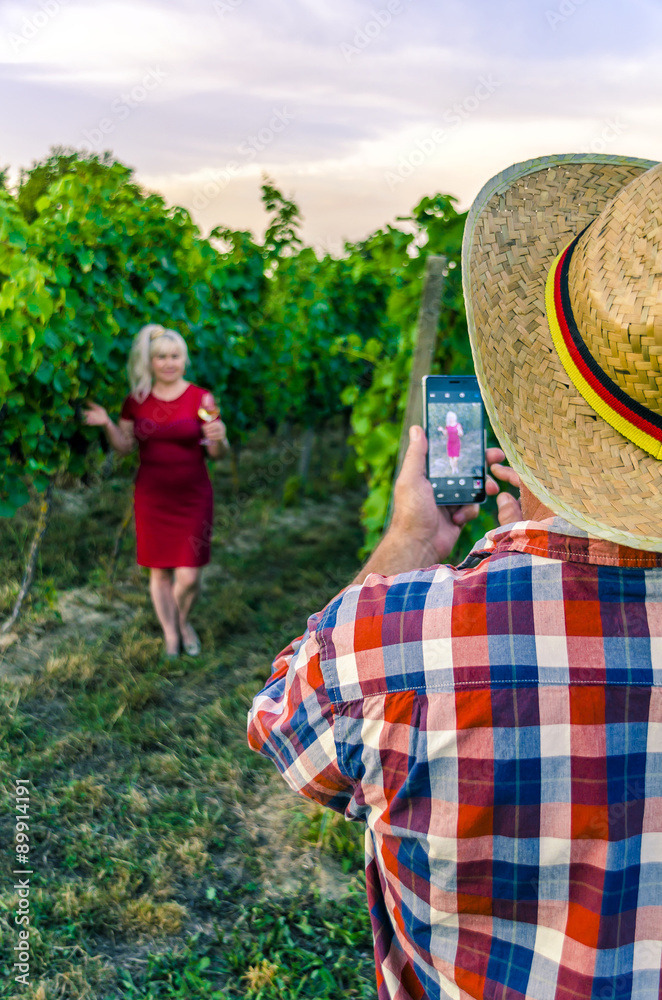 Fototapeta premium Man photographing woman on smart phone on the background of the