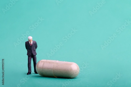 manager dell' industria farmaceutica in miniatura con pillola photo