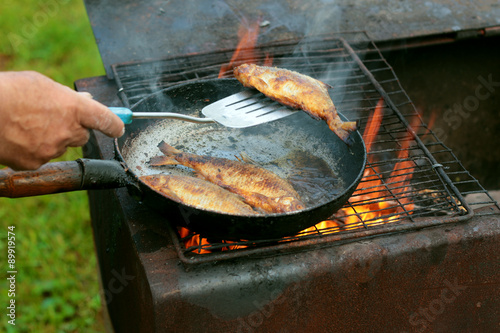 Canvas Print fish frying in oil on the fire