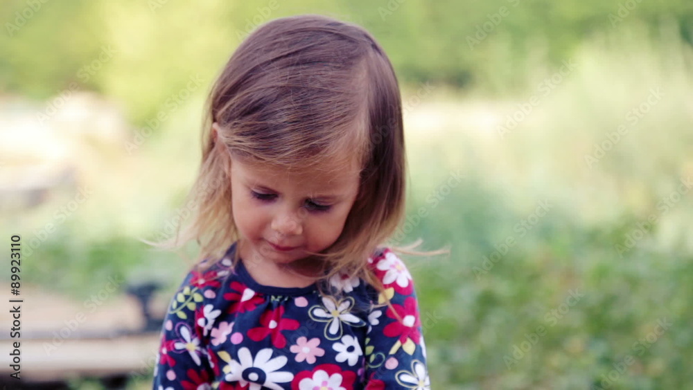 Caucasian little girl eats sausage barbecue. The child eats a girl in nature. Caucasian little girl eats sausage barbecue. The child eats a girl in nature.
