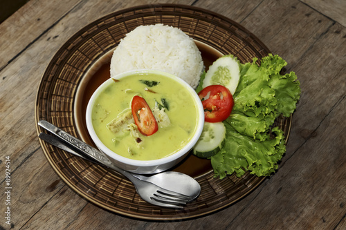 Thai green curry soup and some rice decorated on wooden background, Thai food.