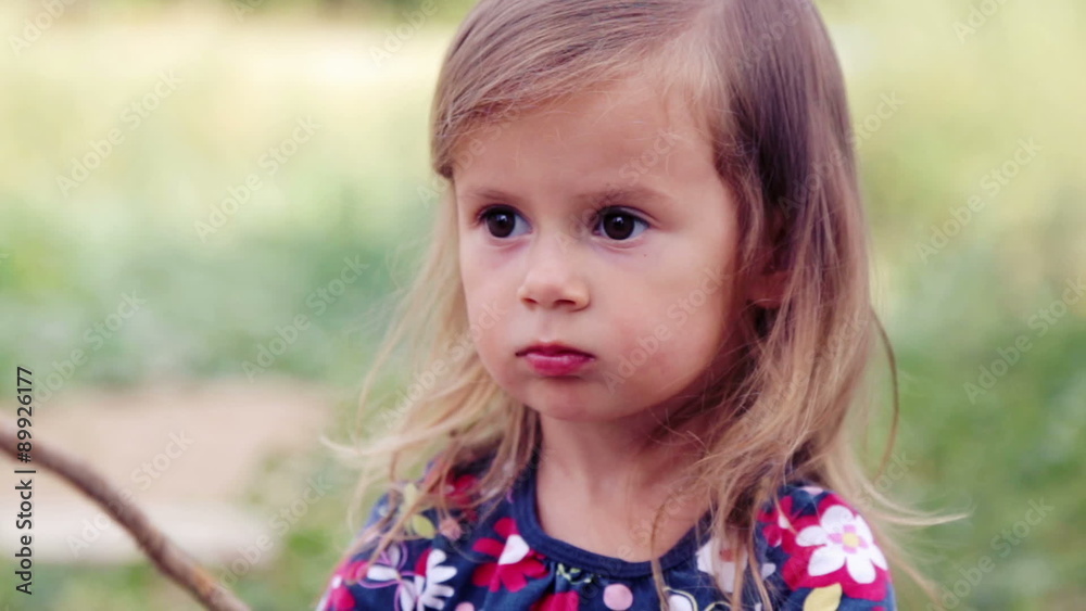 Little girl sitting at home near the grill. Caucasian little girl at a fire near the house. Little girl sitting at home near the grill. Caucasian little girl at a fire near the house.