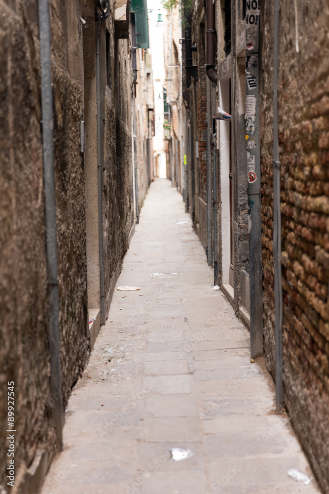 A narrow passage between the gloomy houses. Venice is one of the most popular tourist destinations in the world