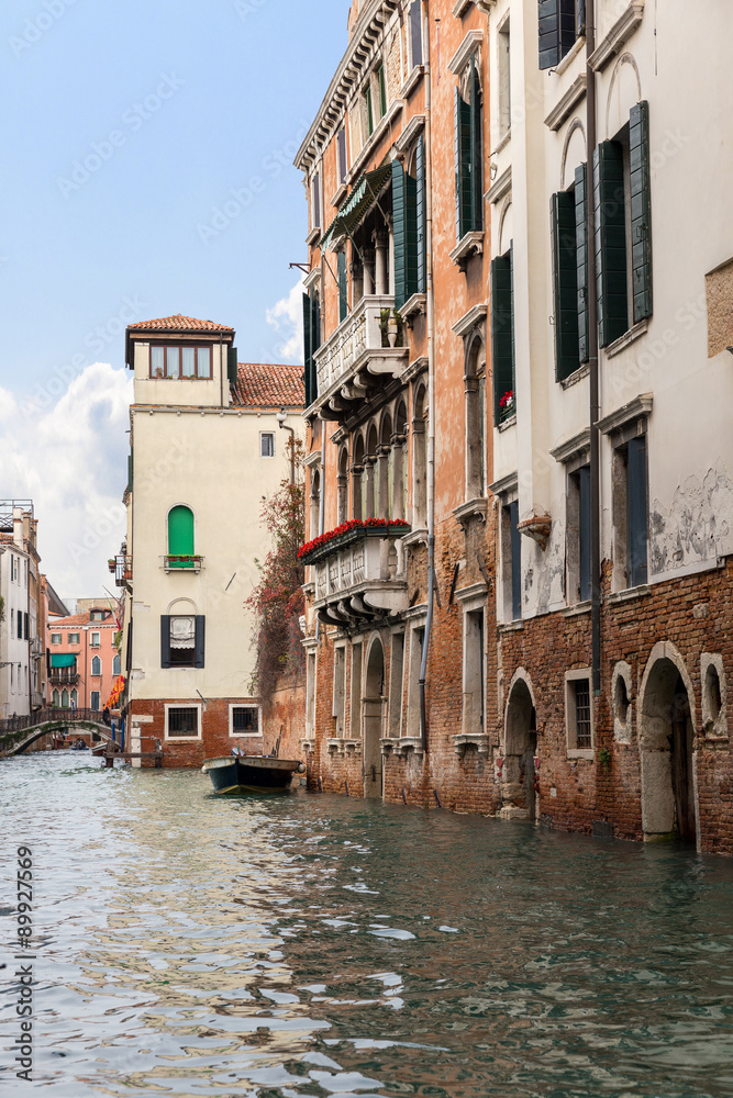 The reflection of a colorful houses in water canal, Venice. Land