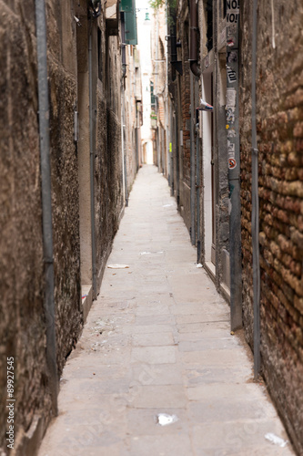 A narrow passage between the gloomy houses. Venice is one of the most popular tourist destinations in the world