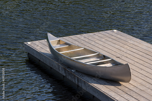 Canvas Print Aluminum canoe on a dock