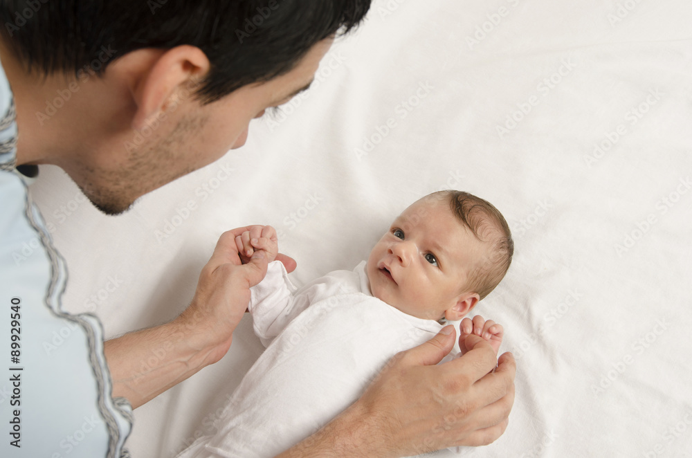 Loving father playing with his new born baby. Father holding baby's hands, looking at him with love. Parent love. Loving father playing with his new born baby. Father holding baby's hands, looking at him with love. Parent love.