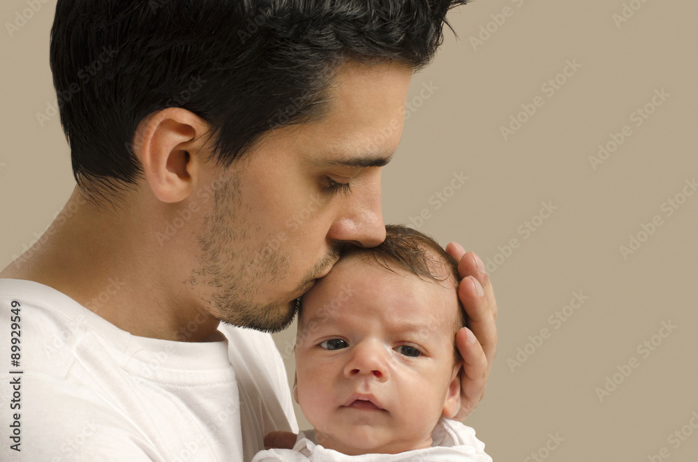 Loving father kissing his new born baby. Father kissing his baby boy forehead and holding him. Parent love. Loving father kissing his new born baby. Father kissing his baby boy forehead and holding him. Parent love.