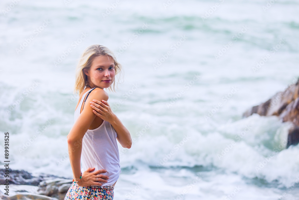 Beautiful young blonde woman posing outdoor at the rocky sea shore Beautiful young blonde woman posing outdoor at the rocky sea shore