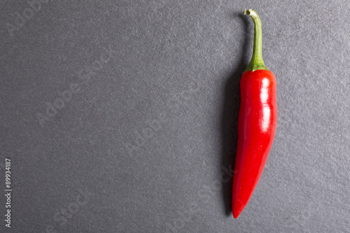 Fresh red chilli on black slate with copy space