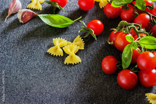 fresh organic cherry tomatoes and paste with basil garlic on a dark background.