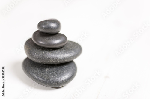 Stacked pile of spa hot rocks on a light wooden surface