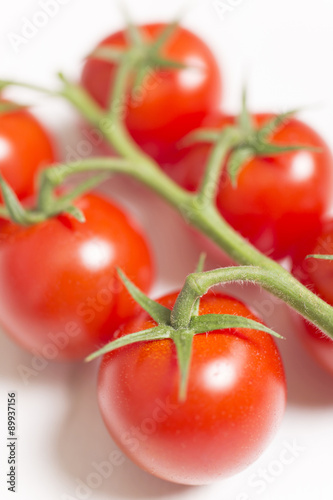 Beautiful fresh tomatoes on a light wooden surface