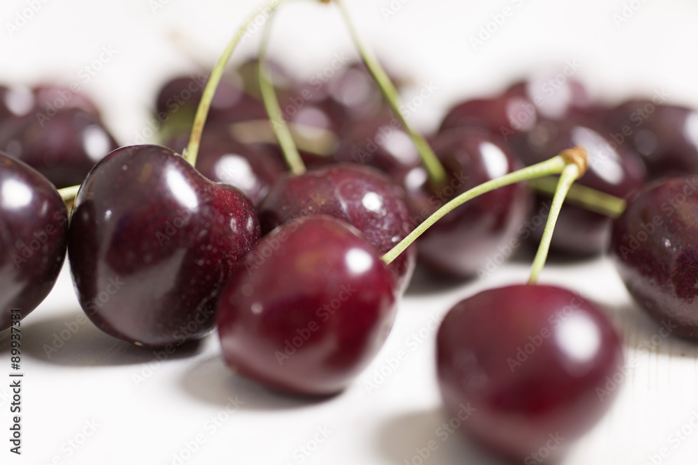 Fresh red cherries on a light wooden kitchen work surface