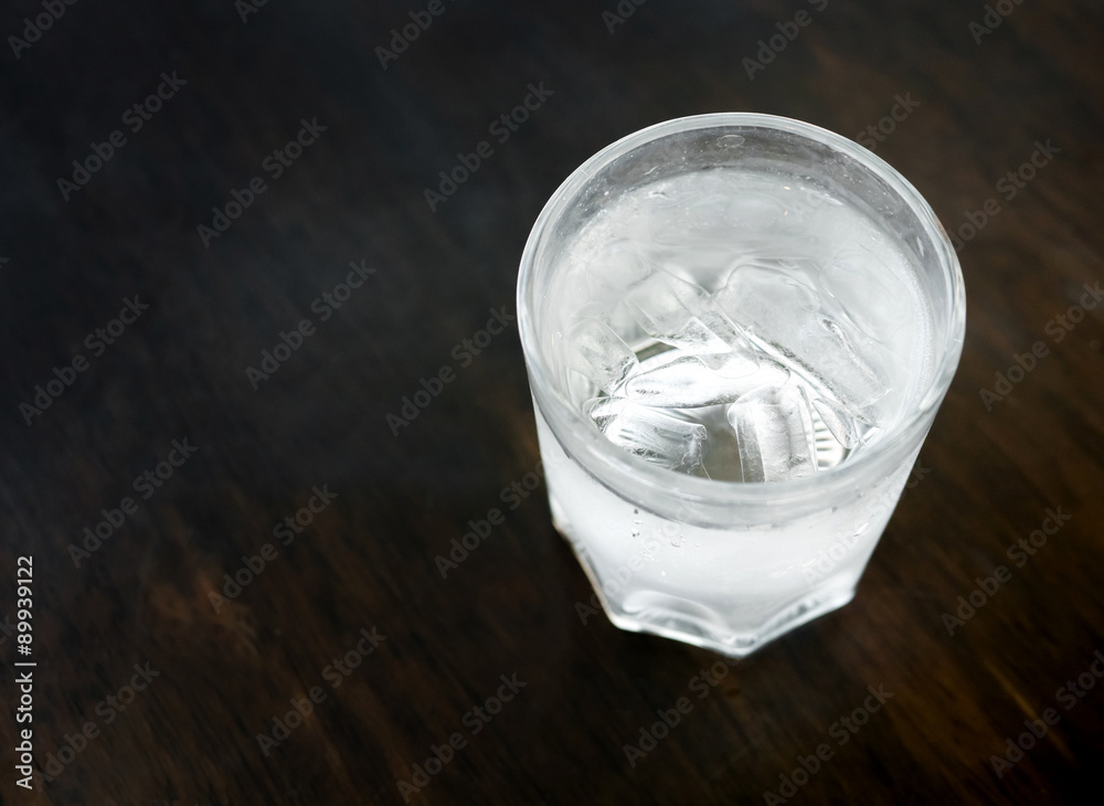 Glasses with ice cubes on wooden table