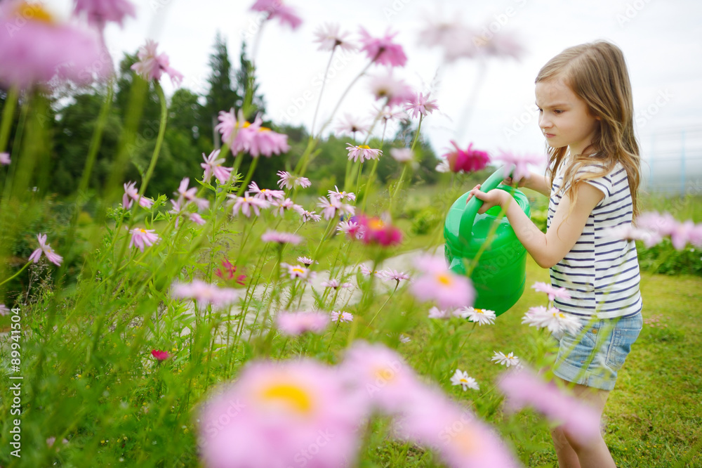 Adorable little girl watering flowers and plants Adorable little girl watering flowers and plants